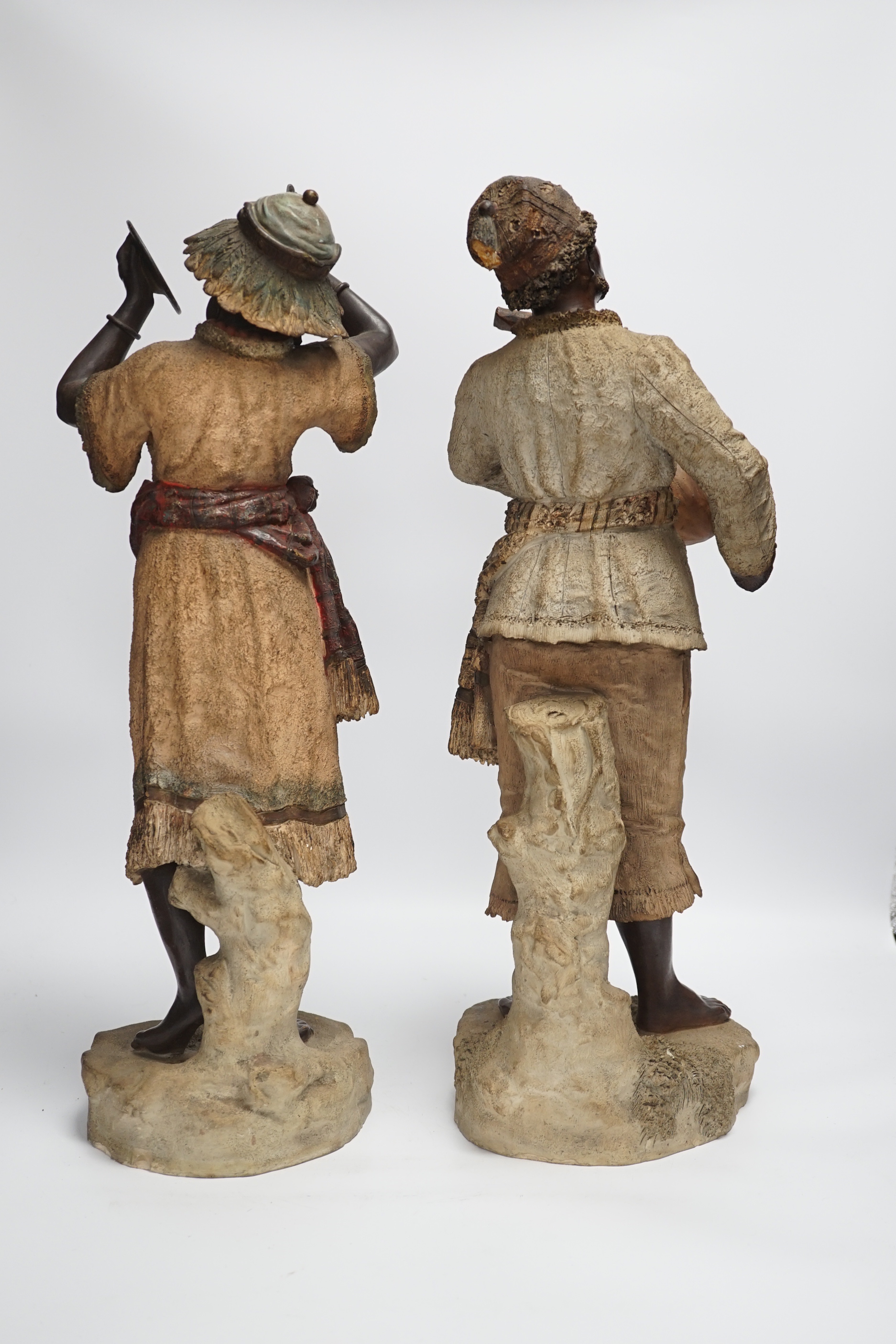 A pair of late 19th century Continental cold painted terracotta Nubian musician figures, 49cm